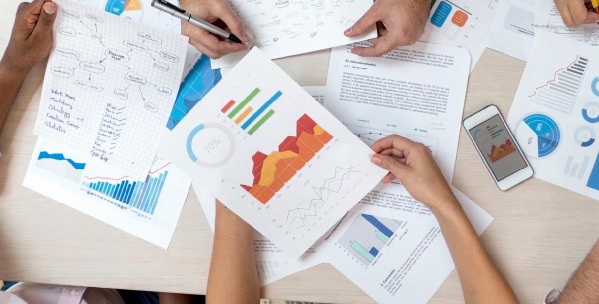 Overhead image of charts and graphs on paper, printed in color