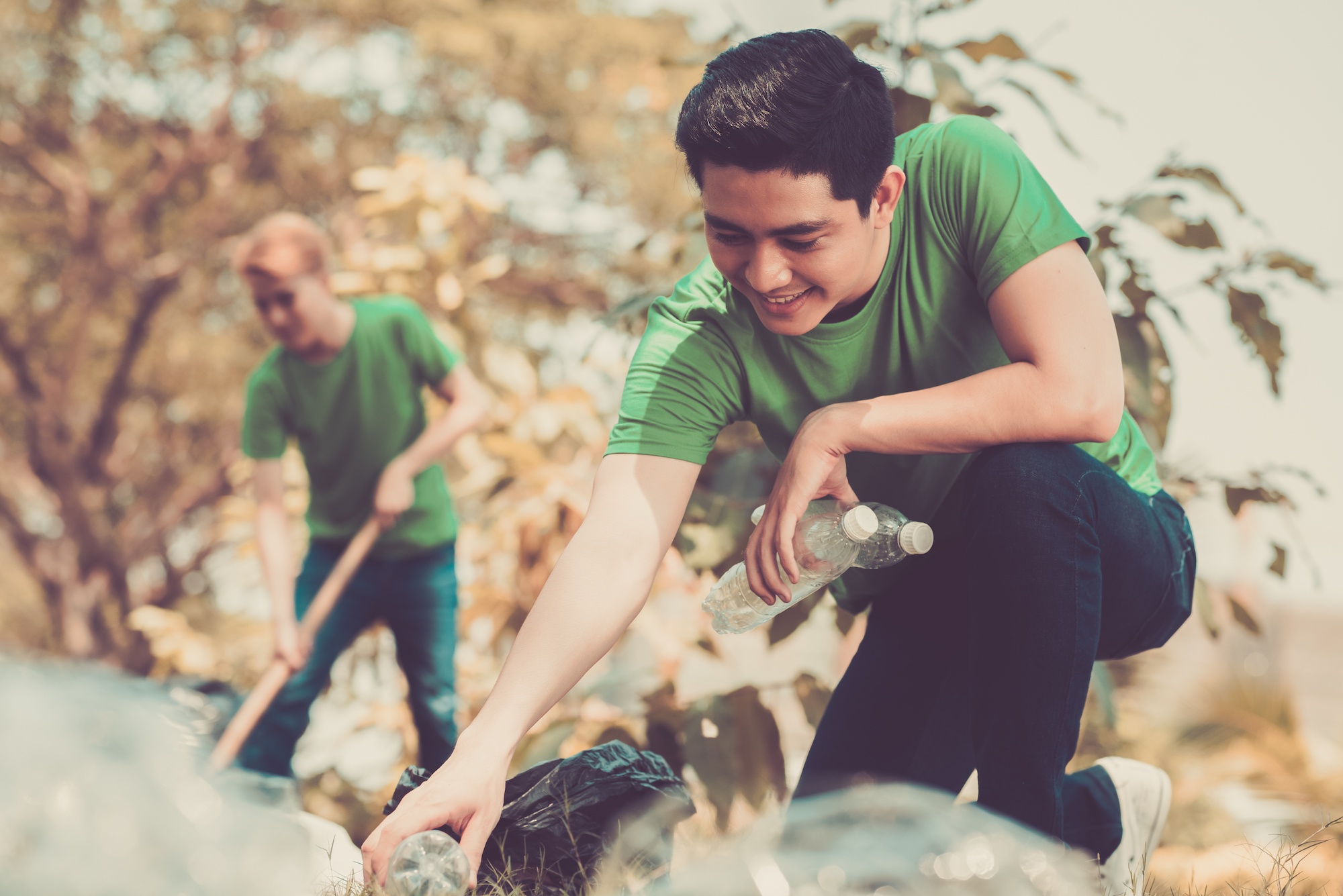 People cleaning up plastic bottles in nature