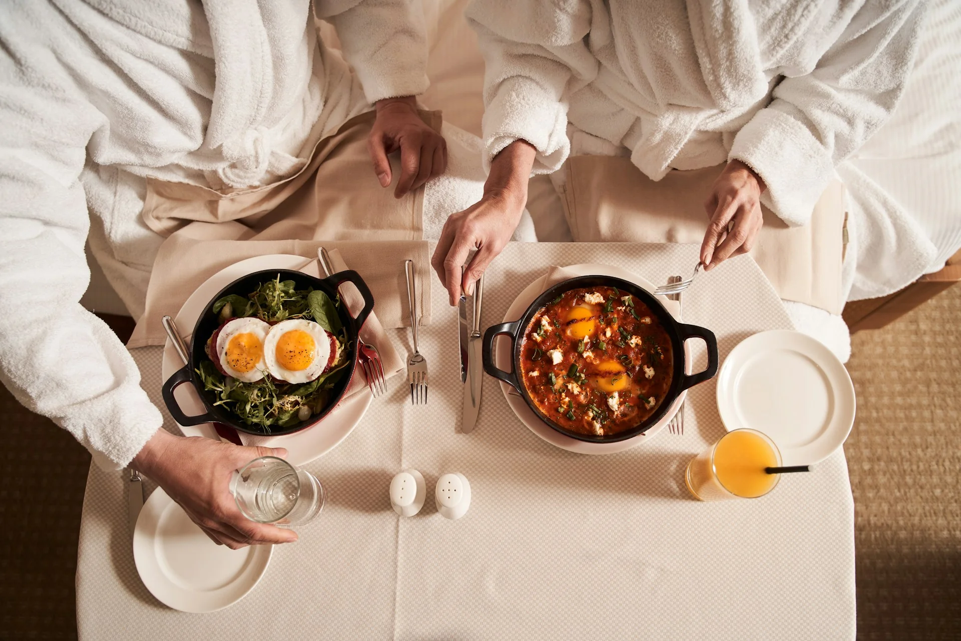 Two people in a hotel eating their breakfast, hospitality.