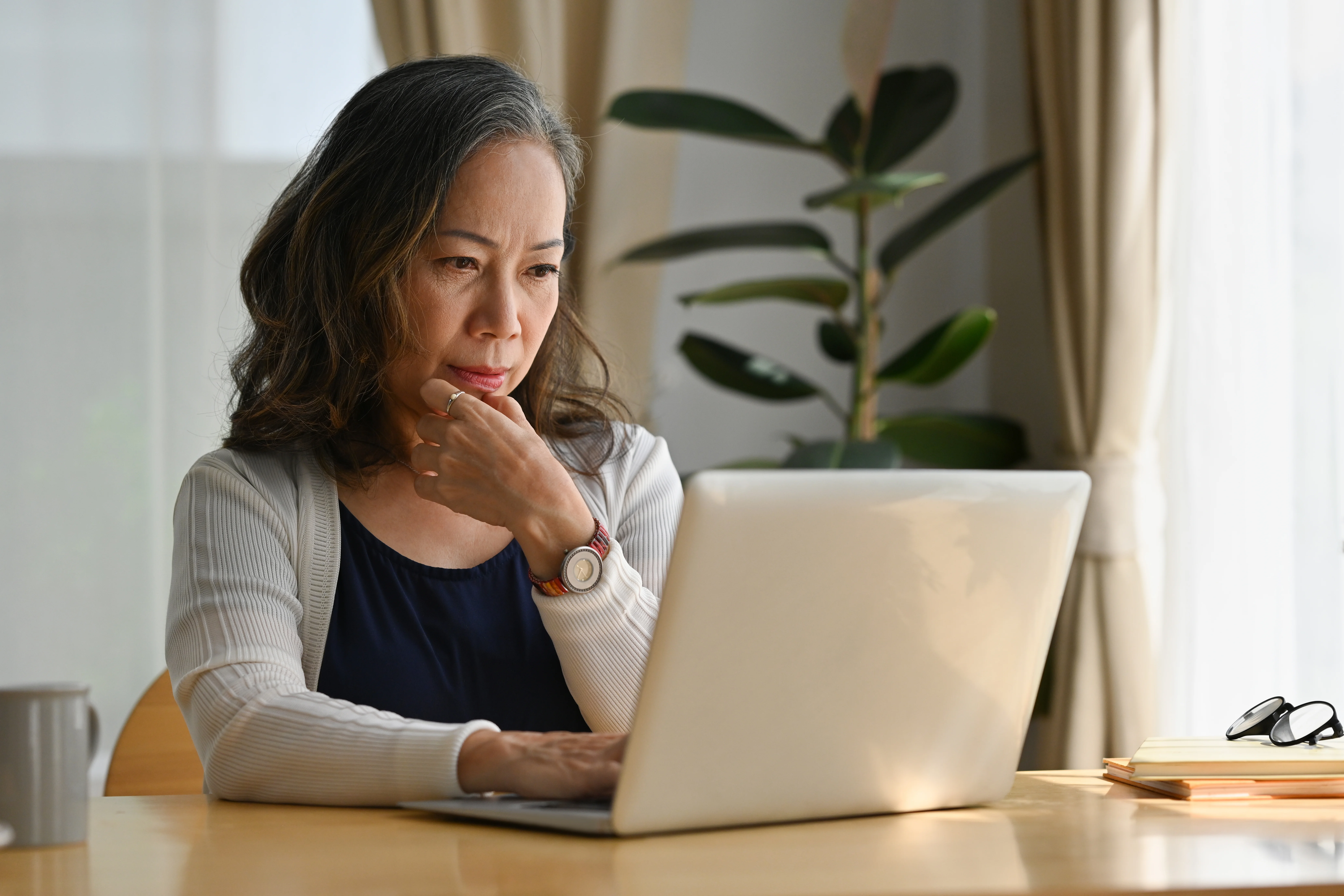 Elderly woman working at home using a laptop