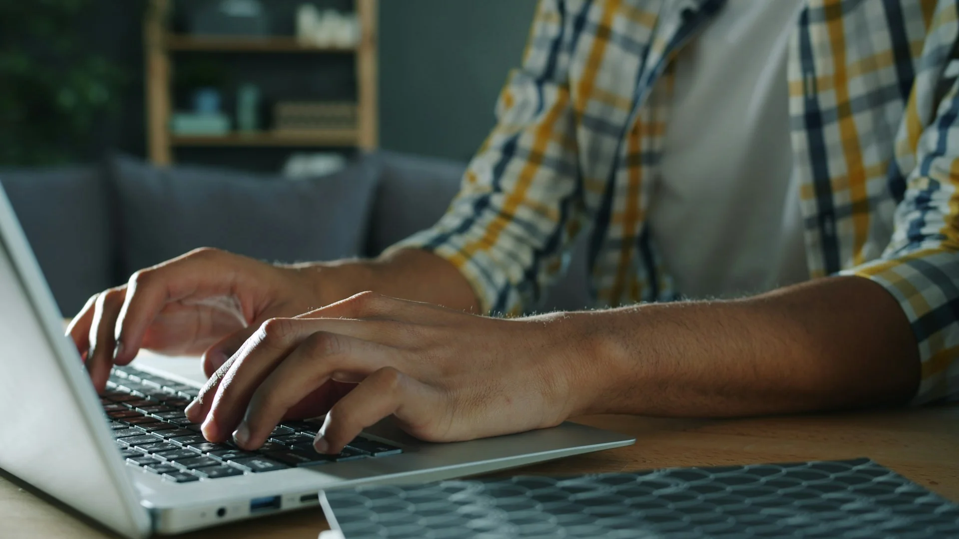 Man in plaid shirt working on his computer