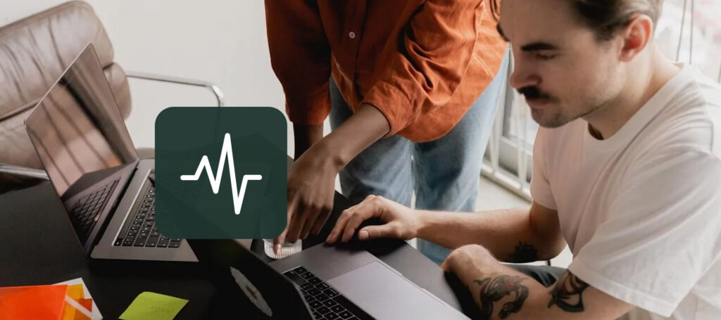 Two coworkers collaborating at laptops in an office, with a pulse or analytics icon overlay representing brand health tracking and performance monitoring.