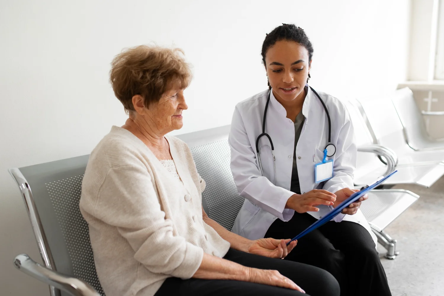 Healthcare provider reviews patient information with an older patient, illustrating how communication shapes patient reviews and healthcare experiences.