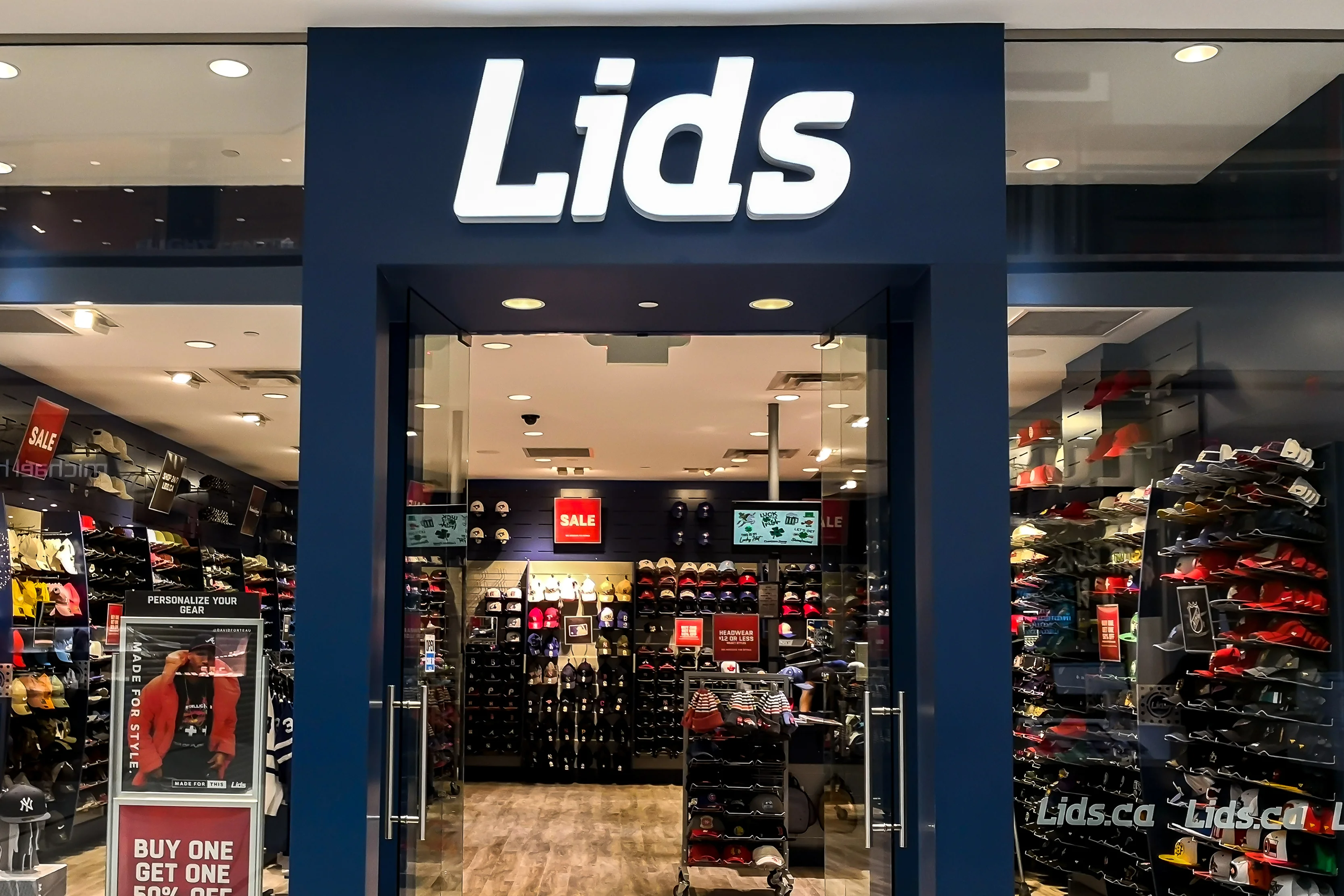 Exterior of a Lids retail store showcasing sports apparel and headwear, highlighting the in-store shopping experience.